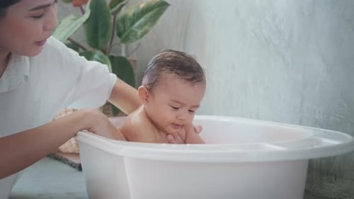 Loving Mother Bathes Her Cute Baby