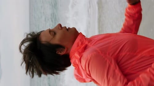 Woman running on beach. Chubby female jogging along seashore. Vertical video