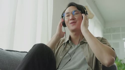 Relaxed Man Enjoying Music on Headphones at Home