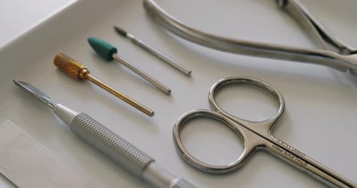 Close Up of Silver Manicure Tools on White Tray