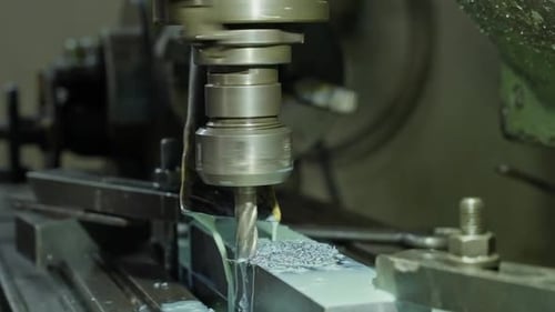 metal milling cuts block with cooling fluid stream in workshop