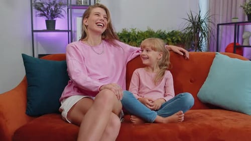 Mother and Daughter Laughing Together on Couch