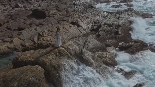 Aerial Drone View of Bride Woman in an White Dress on a Rocky Cliff