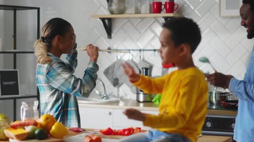 Family Singing and Dancing Together in Kitchen