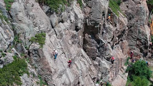 Climbers Ascending Cliff Face with Ropes