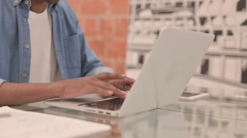 Close Up of African Man Typing on Laptop