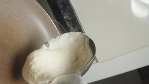 I pour the pancake batter into the pan. POV extreme close-up.
