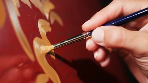 Hand Painting Gold Floral Design on Red Surface