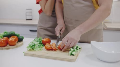 Adults Making Salad in Bright Kitchen