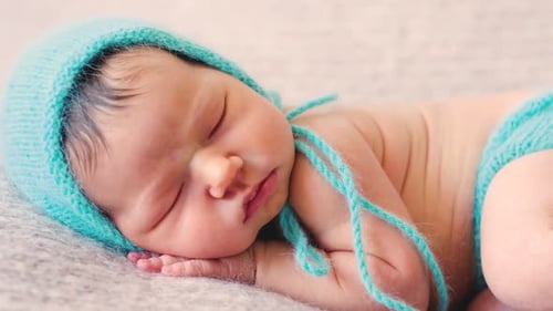 Sweet Newborn Baby Sleeping Peacefully in Blue Knit Outfit