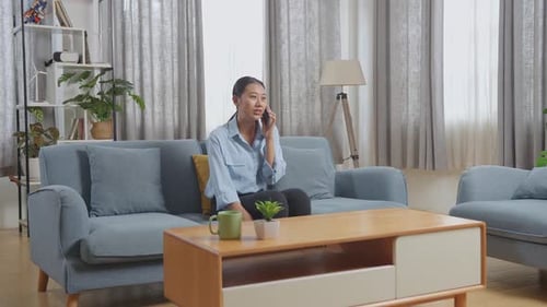 Smiling Woman Talking on Phone in Living Room