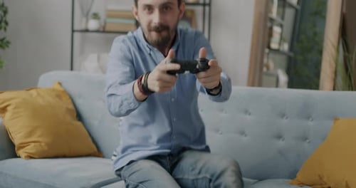 Bearded Man Excitedly Playing Video Games on Couch