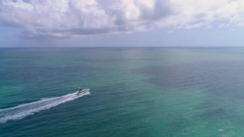 Luxury yacht sailing across vast turquoise ocean waters