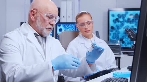 Scientists Discussing Vial in Lab Workplace Setting