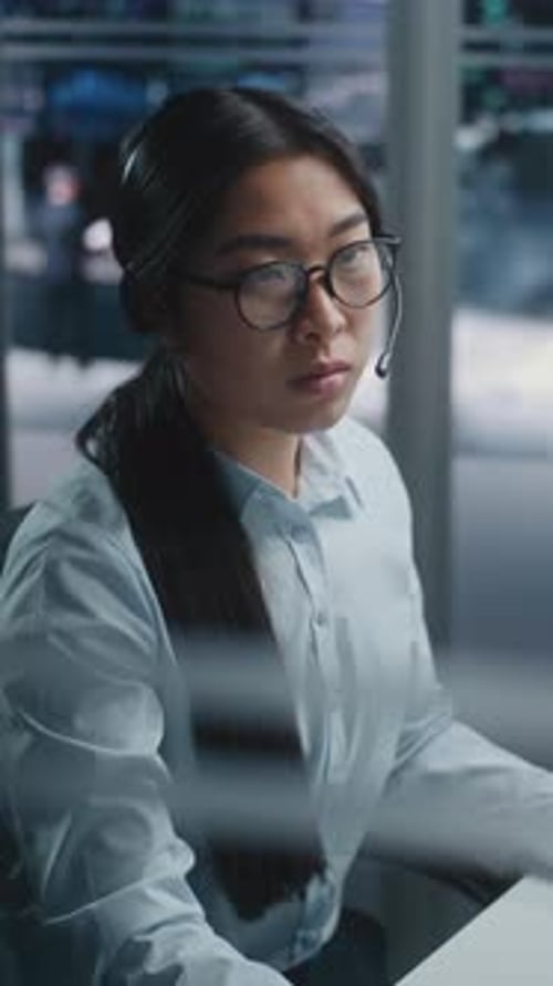 Female Financial Specialist Sits at Innovative Workspace Eyes Scanning Multiple Displays