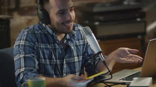 Young man makes a podcast audio recording at home in a garage.