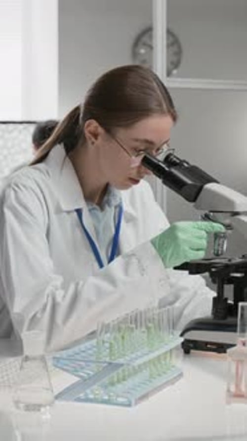 Woman Scientist Working with Microscope in Lab