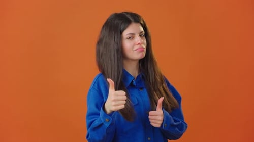 Smiling Woman Gesturing Positively on Orange Background
