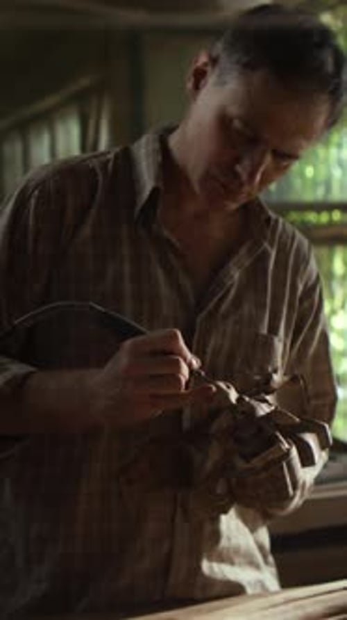 Mature Carpenter Polishes Vintage Wooden Detail with Tool in Shop