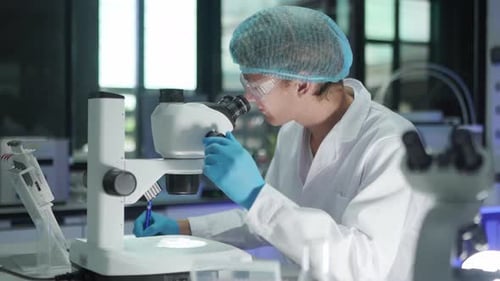 Scientist Using Microscope in Laboratory for Research