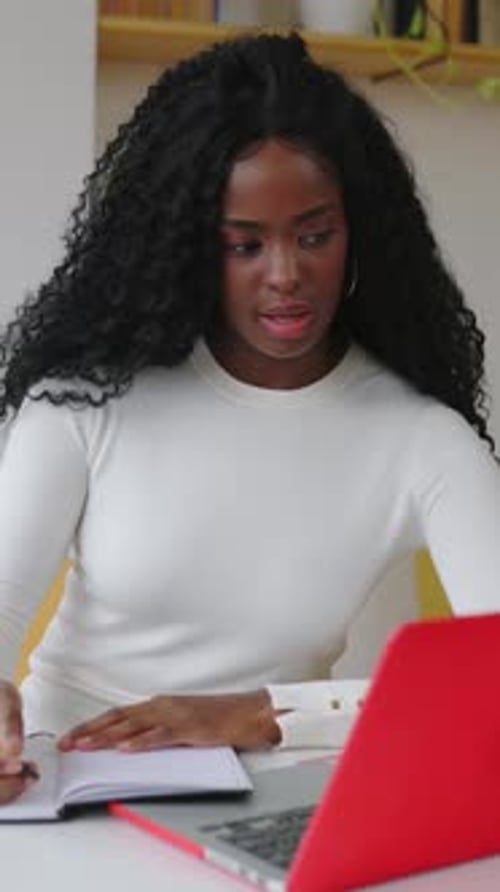 Happy Young Latin American Black Woman Studying Online Using Laptop at Home