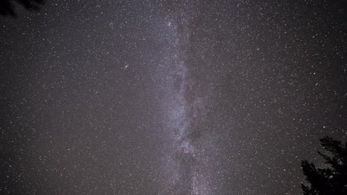 Milky Way bright stars, and satellite trails in the dark night sky.