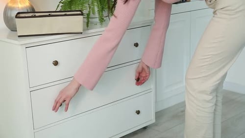 Woman putting organizer with different socks into drawer at home, closeup