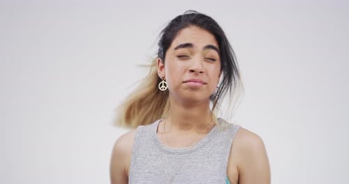 4k video footage of a stressed out young woman standing against a grey background