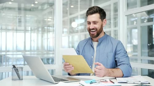 Man Receives Good News at Office with Joy