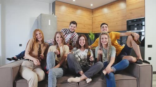 Friends Smiling Together on Couch with Beverages