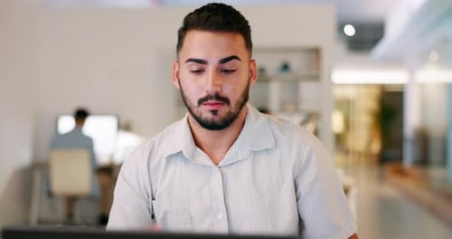 Tired Man Rubbing Eyes at Computer in Office