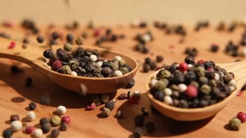 Colorful Peppercorns Falling in Wooden Spoons