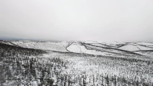 Schneebedeckte Berge enthüllen die Schönheit des Winters in einer abgelegenen Landschaft.