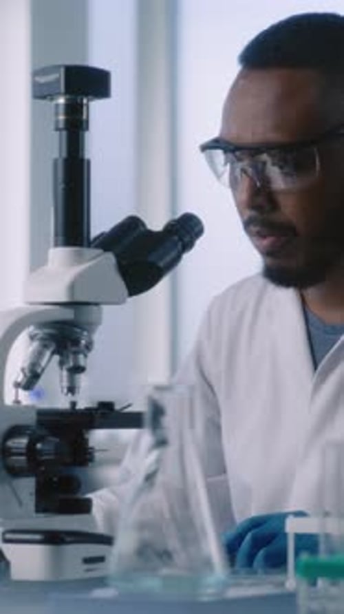 Scientist Using Microscope in Bright Laboratory