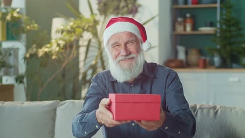 Senior Man Giving Red Christmas Gift Box
