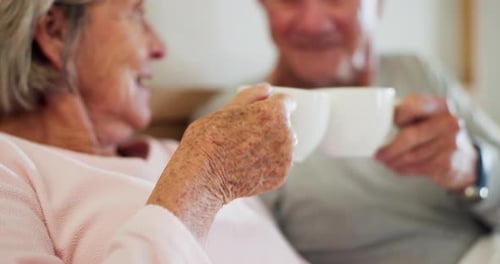 Senior, woman and hand with coffee in home with cheers for delicious, hot and beverage in bed