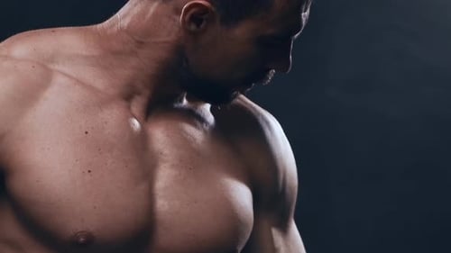 Fitter und sportlicher Bodybuilder auf schwarzem Hintergrund Bodybuilder-Training mit Langhantel Das Konzept von
