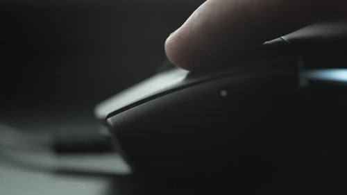 Clicking black computer mouse on a work desk