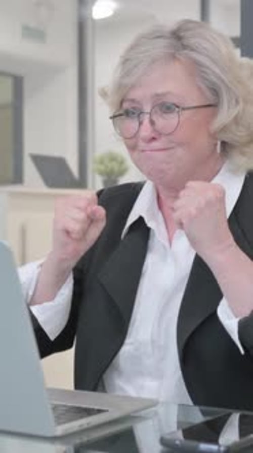 Old Businesswoman Shocked by Loss on Laptop, vertical video