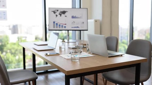 Modern Office Meeting Room with Laptops and Presentation Screen
