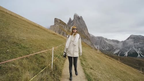 Beautiful Girl Traveler Walking in the National Park of Mountain Seceda in the Dolomites Incredible