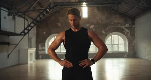 Muscular Man Flexing Biceps in Spacious Gym