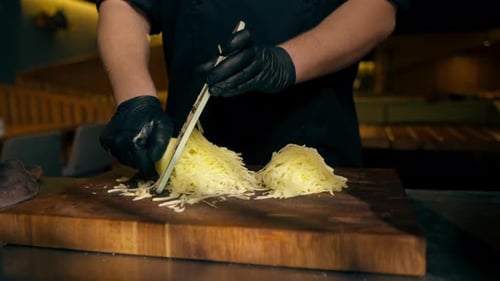 Close Up in a Restaurant in Rib Bar in the Central Hall a Chef in Black Gloves Grates Potatoes on a