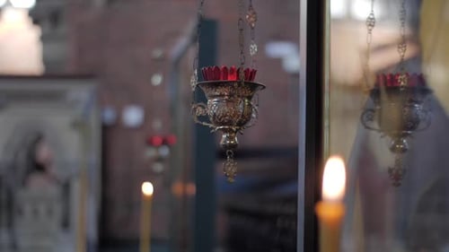 Handheld shot of candles in a church with a dramatic focus pull.