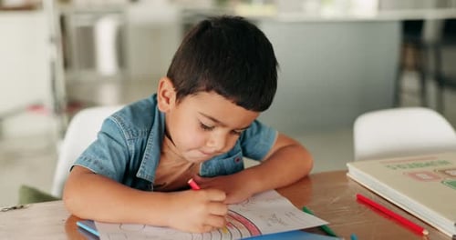 Child Drawing with Crayons at Table