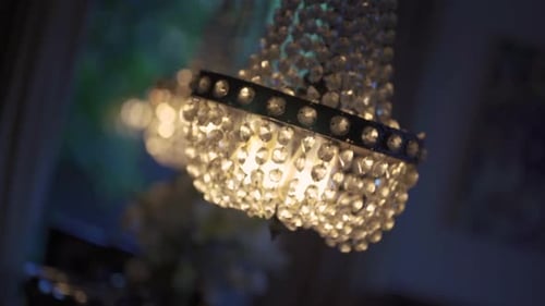Nahaufnahme eines Kristallleuchters, der an der Decke hängt. Bokeh-Hintergrund anderer Kronleuchter