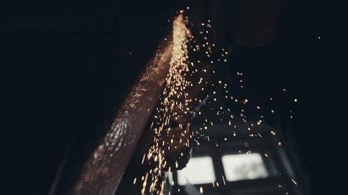 Metalworker in a Factory Creating Fiery Sparks