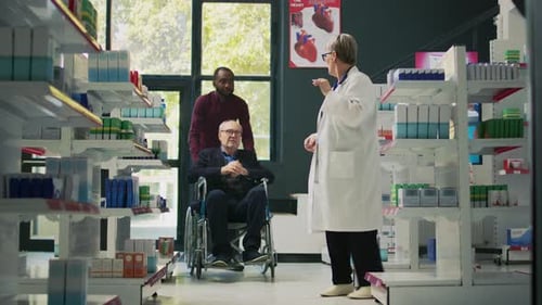 Male Caretaker Helping Senior Man in Wheelchair to Come at Pharmacy Shop