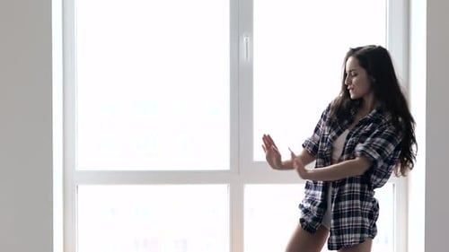 Woman Dances in Front of a Large Window