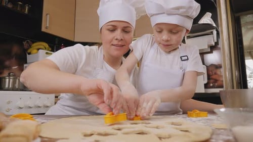 Woman and Boy Cutting Cookie Shapes From Dough